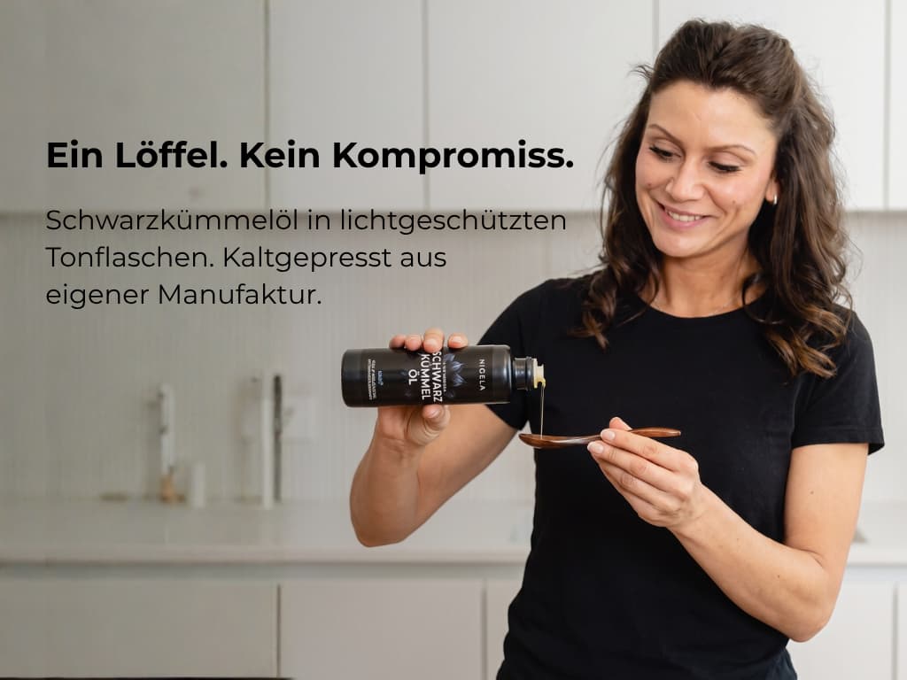 Frau nimmt einen Löffel Nigela Schwarzkümmelöl – frisch gepresst in der eigenen Manufaktur in Bayern