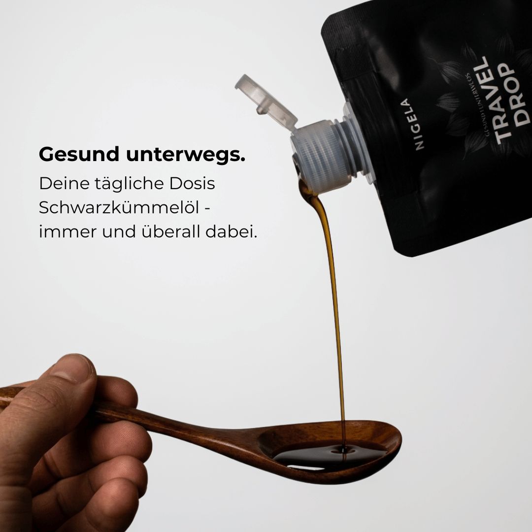 Nigela Travel Drop Schwarzkümmelöl wird auf Holzlöffel gegossen – deine tägliche Dosis, immer und überall dabei