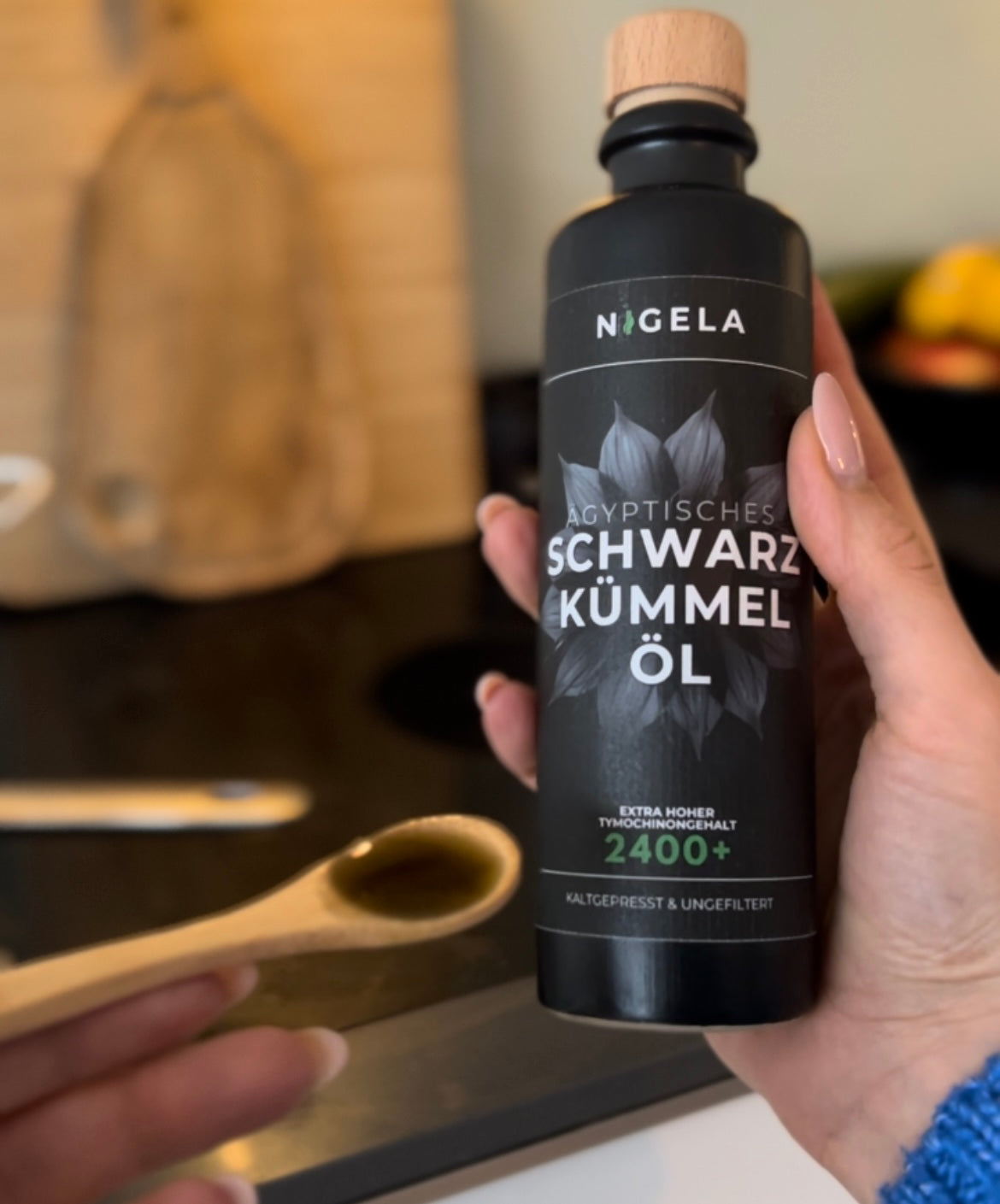 Schwarzkümmelöl kaufen Frau die Nigela Schwarzkümmelöl in der Hand hält.