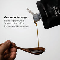 Nigela Travel Drop Schwarzkümmelöl wird auf Holzlöffel gegossen – deine tägliche Dosis, immer und überall dabei
